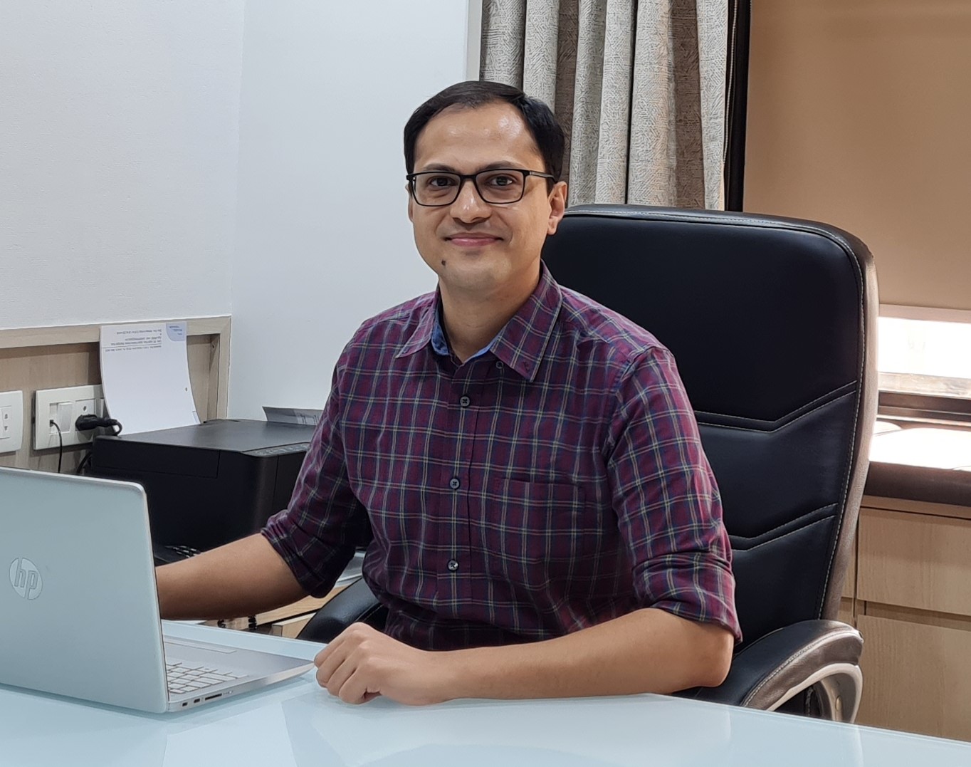 Dr. Nishant Desai at his consulting desk at the Majura Gate clinic in Surat